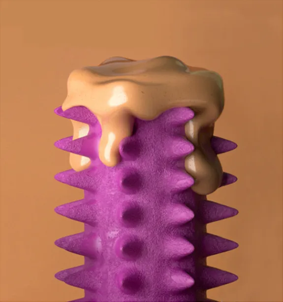Styling_Stills02 Close-up of a purple spiked sculpture topped with glossy tan drips against a warm orange background.